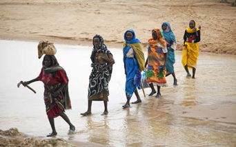Mujeres desplazadas internas en Sudán recogen leña, escoltadas por las fuerzas de mantenimiento de la paz. © UN Photo/Albert González Farran. io