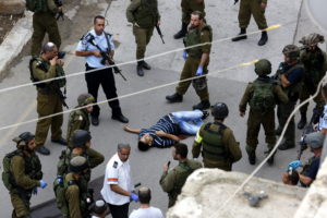 Soldados israelíes permanecen junto al palestino Said al Atrash, tras el ataque que tuvo lugar ayer junto a la Cueva de los Patriarcas en Cisjordania, cerca de Hebrón en el que, según la policía israelí, este intentó apuñalar a un agente de seguridad/EFE.
